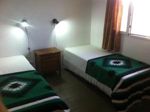 a room with two beds and a night stand with two lamps at Casa en Chapadmalal in Mar del Plata