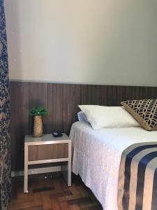 a bedroom with a bed and a table with a potted plant at Hotel Requinte in Dois Vizinhos