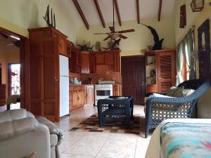 a kitchen with wooden cabinets and a white refrigerator at Alan's Paradise Hotel in Placencia