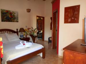 a bedroom with a bed with a swan on it at Alan's Paradise Hotel in Placencia Village