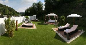 a yard with chairs and umbrellas on the grass at Hotel & SPA Waldecker Hof in Willingen