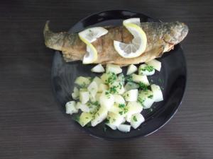 ein Teller mit Fisch und Gemüse auf dem Tisch in der Unterkunft Pensiunea Ciobanelu in Malaia