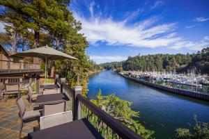 a view of a river with tables and chairs at Noyo Harbor Inn in Fort Bragg