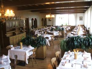a dining room filled with tables and chairs with plants at Hotel Seggiovia in Folgaria