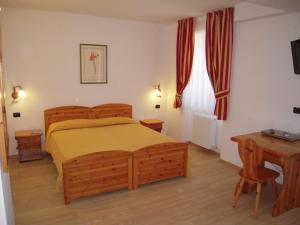 - une chambre avec un lit, une table et un bureau dans l'établissement Hotel Seggiovia, à Folgaria
