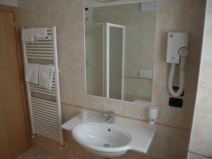 ein Bad mit einem Waschbecken und einem Spiegel in der Unterkunft Hotel Seggiovia in Folgaria