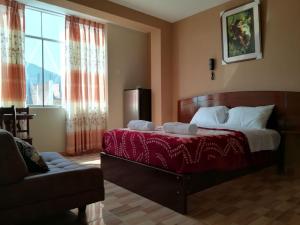 钦博特Hotel Real Chimbote的一间带床、沙发和窗户的卧室