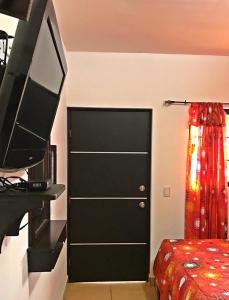 a bedroom with a black closet with a television next to a bed at Hotel Los Valles in Creel