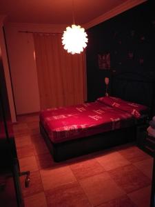 1 dormitorio con cama roja y lámpara de araña en Apartment South Tenerife, en San Isidro