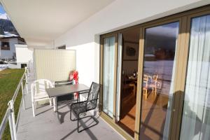 a patio with a table and chairs on a balcony at Dischmastrasse - Vonwyl in Davos