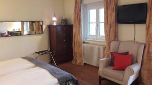 a bedroom with a bed and a chair and a television at Pension Prinz in Munich