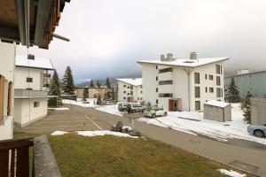 a view of a parking lot with snow and buildings at Etania in Davos