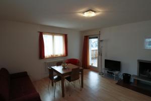 a living room with a table and a television at Etania in Davos