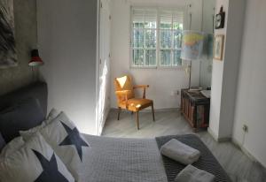 Un dormitorio con una cama y una silla y una ventana. en Frente al mar, en Benalmádena
