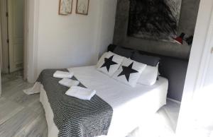 Un dormitorio con una cama con almohadas blancas y negras. en Frente al mar, en Benalmádena 14 fotos más