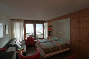 - une chambre avec un lit, un canapé et un bureau dans l'établissement Richmond - 204, à Davos