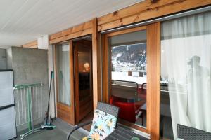 a room with a balcony with glass doors and a window at Richmond - 204 in Davos