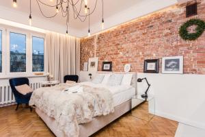 a bedroom with a bed and a brick wall at SleepHome Poznanska in Warsaw