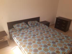1 dormitorio con 1 cama con edredón azul y marrón en joli appartement 4 chambres, en Oujda