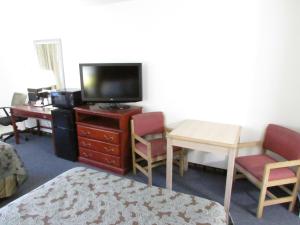 sala de estar con TV, mesa y sillas en Parsons Inn Downtown Parsons,Tn, en Parsons