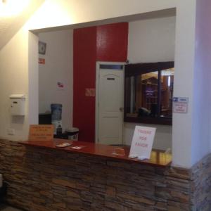 a kitchen with a counter with a sign that says danger for food at Samana Hostal in Otavalo