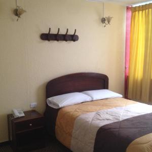 a hotel room with a bed and a window at Samana Hostal in Otavalo +24 photos