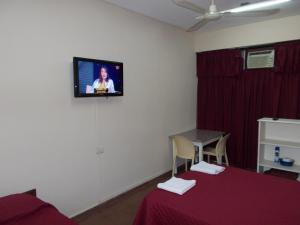 Habitación con TV colgada en la pared en Apart Office en San Miguel de Tucumán