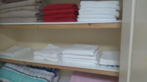 uma pilha de toalhas numa prateleira num armário em Lake Estate Stay em Perth
