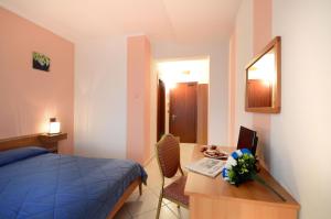 Royal Hotel Montevergine في Ospedaletto dʼAlpinolo: غرفة نوم مع سرير ومكتب مع جهاز كمبيوتر