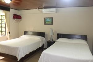 a hotel room with two beds and two lamps at Hotel Santa Maria Inn in Alajuela