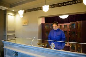 une femme debout derrière un comptoir dans une pièce dans l'établissement Rc Hotel Kyoto Yasaka, à Kyoto