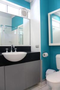 a bathroom with a sink and a toilet at Crystal Garden Resort & Restaurant in Cairns