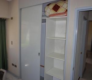 a white closet with white shelves in a room at Mendoza Deluxe in Mendoza