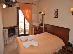 una camera da letto con un letto con un arco sopra di Megdovas Hotel a Kalyvia