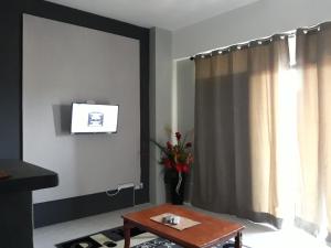 ein Wohnzimmer mit einem Tisch und einem Fenster in der Unterkunft Budget Studio Apartment in Kuah