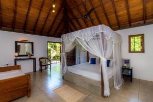 a bedroom with a bed with a canopy at Palm Paradise Cabanas & Villas Beach Resort in Tangalle