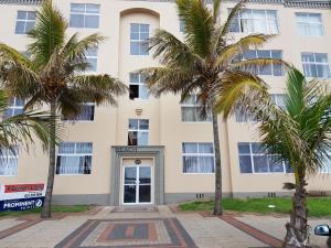 un edificio con palme di fronte ad esso di Beachurst Apartment a Durban