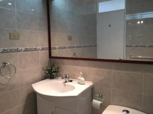 a bathroom with a sink and a toilet and a mirror at Departamento 8 Norte, Torre del Mar in Viña del Mar +24 photos