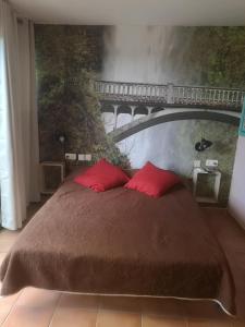 Un dormitorio con una cama con almohadas rojas y un puente en Casa Rosa, en Eilat