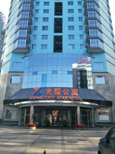 un edificio azul con un cartel delante en Guangyao Service Apartment Beijing Ritan, en Beijing