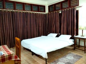 sypialnia z 2 łóżkami z zasłonami i stołem w obiekcie Tranqville w mieście Guwahati