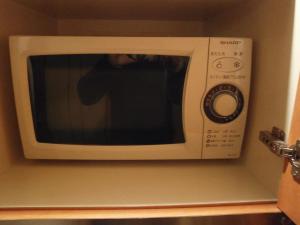 a person taking a picture of a microwave at Hotel Green Hill in Fukaya