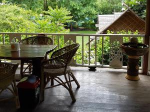 a patio with a table and chairs on a porch at Ban Sabai Sabai Guest House in Kanchanaburi City