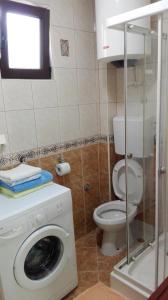 uma casa de banho com uma máquina de lavar roupa e um WC em Apartments Penovic em Kotor