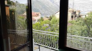 uma vista a partir de uma janela de uma varanda com uma montanha em Apartments Penovic em Kotor