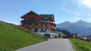 ein Gebäude an der Seite eines Hügels neben einer Straße in der Unterkunft Noldis Apart in Serfaus