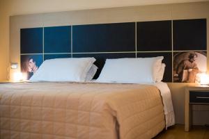 a bedroom with a large bed with two pillows at Hotel Diana in Ravenna