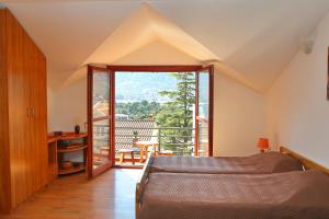 sypialnia z łóżkiem i dużym oknem w obiekcie Loki Apartments w Kotorze