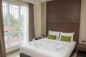 a bedroom with two beds and a large window at Green Eden Hotel in Manado