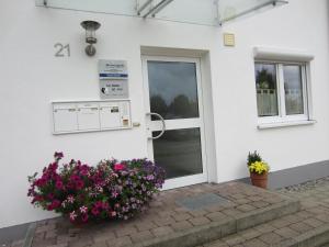 a white house with a door and flowers at Christine Oparaugo - Privatzimmer mit Bad in Leutkirch im Allgäu